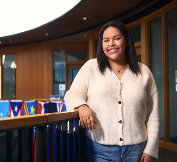 امرأة ترتدي تي شيرتًا عليه نجمة وتتكئ على سياج